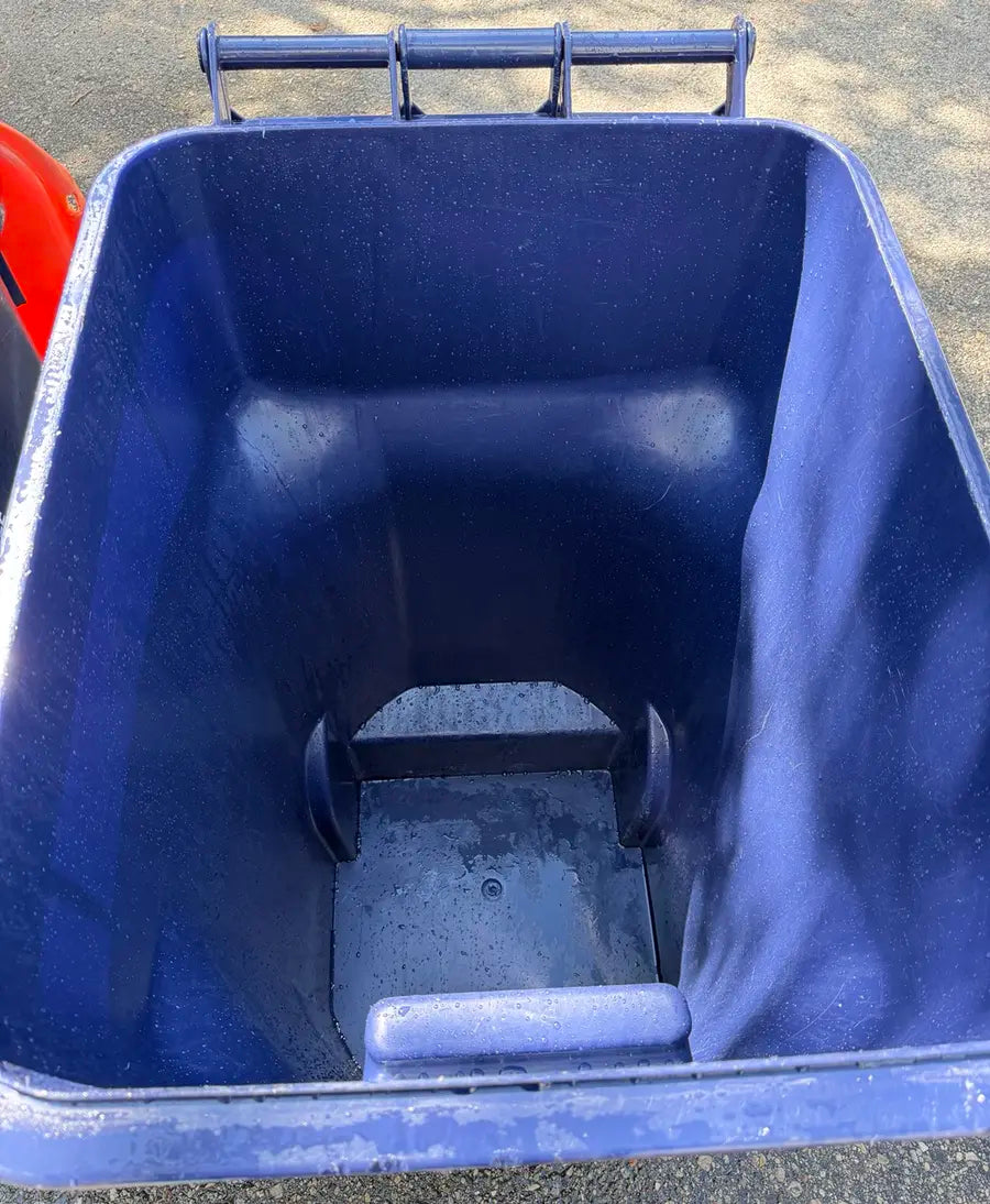 Same blue rollaway trash bin after BC Bin Clean service with debris and buildup removed