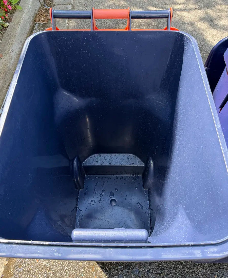 Same red-handled rollaway bin after professional curbside cleaning