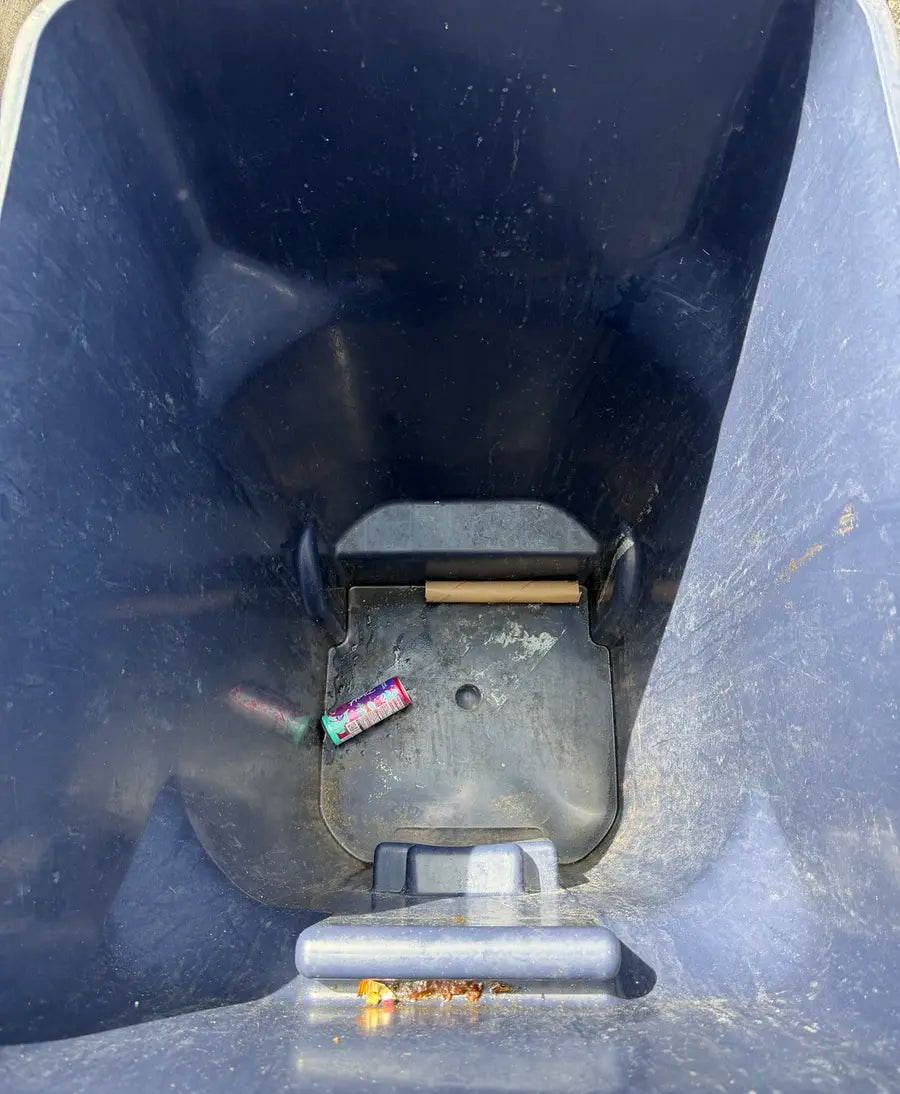 Second dirty rollaway bin before cleaning with loose trash and residue inside
